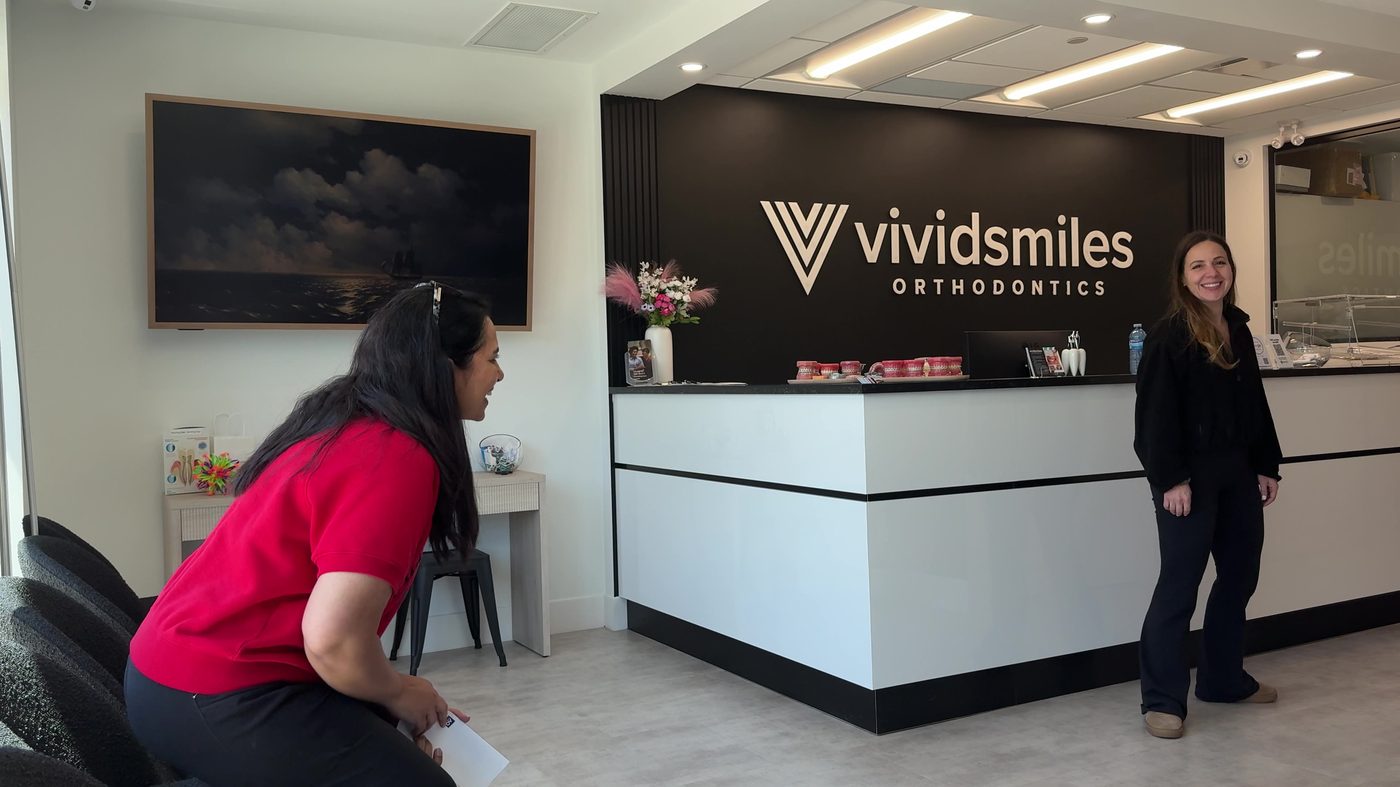 A new patient being welcomed at the Vivid Smiles front desk